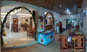 ein Restaurant mit einem Torbogen, Tischen und Stühlen in der Unterkunft Novo Hotel & Restaurante in Manacapuru