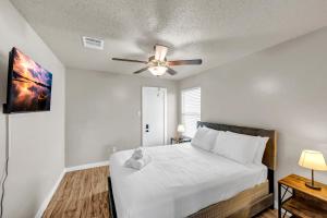 ein Schlafzimmer mit einem weißen Bett und einem Deckenventilator in der Unterkunft McKinney 4BR, Family OR Work , Near Frisco & Allen in McKinney
