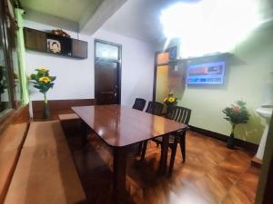 a dining room with a wooden table and chairs at The Nature Villa Kalpa in Chini