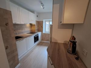 a kitchen with white cabinets and a wooden floor at La Casa di Elvira-Primo Piano in Piaia