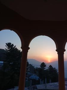 un tramonto visto attraverso le finestre di un edificio di PinesHome Villa a Murree