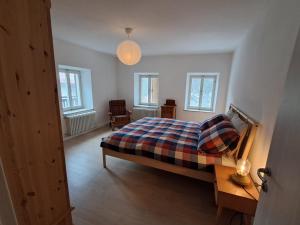 a bedroom with a bed and a table and windows at La Casa di Elvira-Primo Piano in Piaia