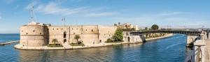 a castle in the middle of the water with a bridge at casa adriana in Taranto