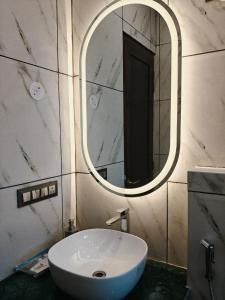a bathroom with a white sink and a mirror at The Himalayan Residency in Duttnager