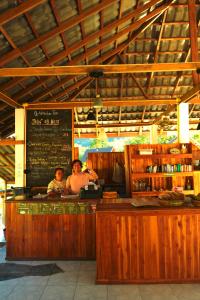 zwei Personen stehen in einer Bar in einem Restaurant in der Unterkunft Eco Farm Stay and Hostel in Nongkhiaw