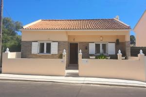 una casa con una recinzione bianca davanti di Moradia T2 com vista para a serra - Alverca a Alverca