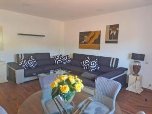 un soggiorno con un divano e un tavolo con fiori di Moradia T2 com vista para a serra - Alverca a Alverca