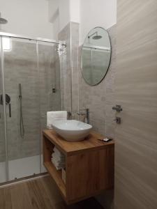 a bathroom with a sink and a shower with a mirror at Ciccone's Rooms in Larino
