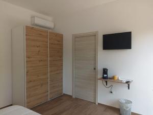 a bedroom with a closet and a television on a wall at Ciccone's Rooms in Larino