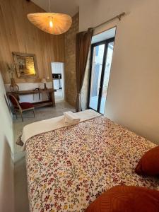 una camera da letto con un letto grande con una grande finestra di Les Petits Jardins de Cissé Chambre de Charme a Cissé