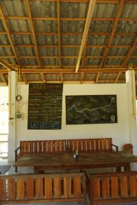 ein Esszimmer mit einem Tisch und einer Tafel an der Wand in der Unterkunft Eco Farm Stay and Hostel in Nongkhiaw