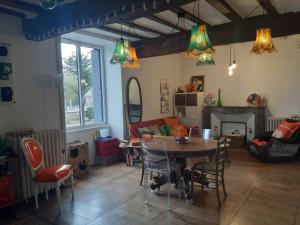 a living room with a table and chairs and a couch at Chambre d'hôtes dans maison de charme in La Gravelle