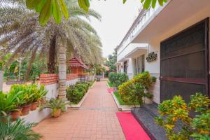 einen Backsteinsteg vor einem Gebäude mit Pflanzen in der Unterkunft Mount Retreat Resorts - Madurai in Madurai