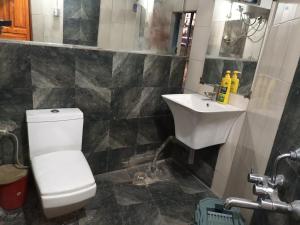 a bathroom with a white toilet and a sink at Dzükou Guest House in Kohīma