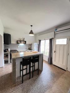 a kitchen with a large island in a room at Casa Raíz 2 habitaciones para 4 personas frente al río in Santa Rosa de Calamuchita +14 photos