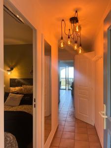 Superbe appartement les Restanques du golfe de Saint tropez في غريمو: ممر يؤدي إلى غرفة نوم بها سرير وأضواء +15 صورة