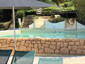 una piscina con scivolo e ombrellone di Superbe appartement les Restanques du golfe de Saint tropez a Grimaud