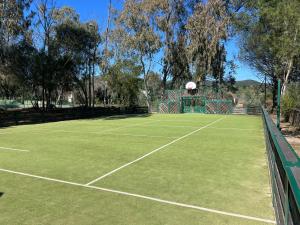 Superbe appartement les Restanques du golfe de Saint tropez في غريمو: ملعب تنس عليه طوق كرة سلة