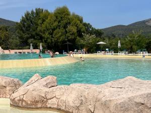 Superbe appartement les Restanques du golfe de Saint tropez في غريمو: مسبح فيه ناس في الماء