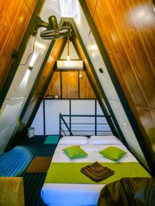 a bed in the middle of a small room at White Moon Cabin & Cottage in Ella