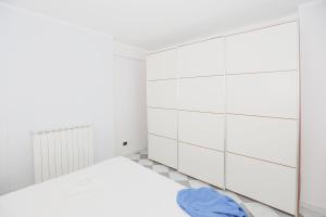 a white bedroom with a bed and white cabinets at Polanesi Sea View - Garden - AC - Free Park - Super Wi Fi in Sori +19 photos