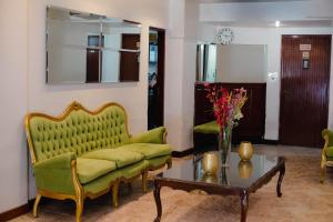 un soggiorno con un divano verde e un tavolo di Hotel Altos del Norte a San Miguel de Tucumán Altre 6 foto