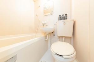 a white bathroom with a toilet and a sink at The Nest Koenji Cozy Stay near Station Easy Access to Shinjuku in Tokyo +9 photos