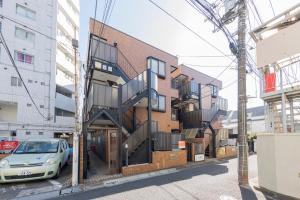 a building with a spiral staircase on the side of a street at The Nest Koenji Cozy Stay near Station Easy Access to Shinjuku in Tokyo