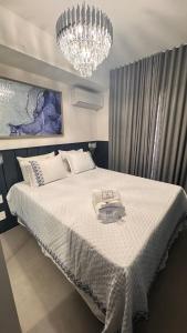 a bedroom with a large bed with a chandelier at Apartamento Luxuoso 62 - São João in Sao Paulo +119 photos