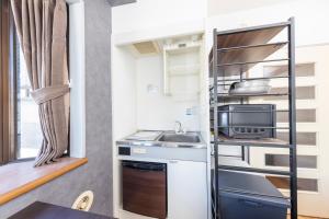 a small kitchen with a sink and a microwave at The Nest Koenji Cozy Stay near Station Easy Access to Shinjuku in Tokyo