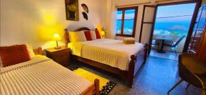 Un dormitorio con dos camas y una gran ventana. en Knossos Skynest, en Palaikastro