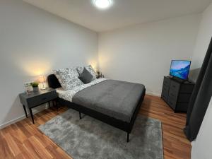 een slaapkamer met een bed en een flatscreen-tv bij FlexStay Room 10 in Karlsruhe
