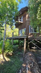 een blokhut met een veranda en een houten terras bij El octógono in Tigre