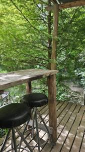 een tafel en twee krukken op een houten terras bij El octógono in Tigre