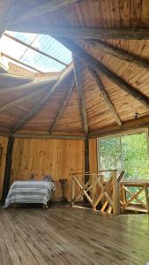 een slaapkamer met een bed in een houten kamer met ramen bij El octógono in Tigre