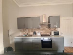 a kitchen with a sink and a microwave at Tyneside Apartments 5 Minutes From City Centre in Newcastle upon Tyne +3 photos