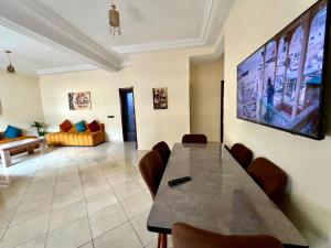 非斯Appart Hotel Fes - Joud Families & Travelers的客厅里有一张桌子和一张沙发 更多16张照片