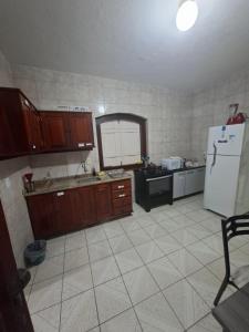 Casa de Hospedagem Flores Paraty 2 في باراتي: مطبخ بخزائن خشبية وثلاجة بيضاء +22 صورة