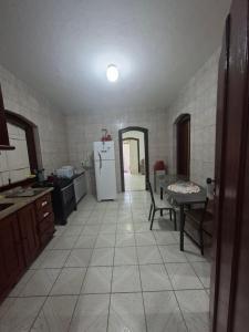 Casa de Hospedagem Flores Paraty 2 في باراتي: مطبخ به ثلاجة وطاولة بداخله