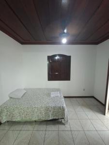 Casa de Hospedagem Flores Paraty 2 في باراتي: غرفة نوم مع سرير وخزانة على الحائط