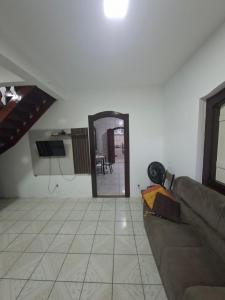 Casa de Hospedagem Flores Paraty 2 في باراتي: غرفة معيشة مع أريكة ومرآة