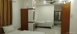 a small room with two beds and a mirror at Hotel Shree Elite in Ratlām