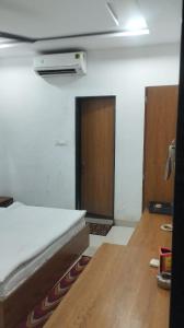 a room with a bed and a hallway with a door at Hotel Shree Elite in Ratlām