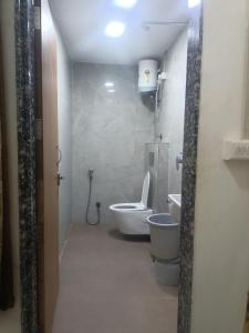 a small bathroom with a toilet and a sink at Hotel Shree Elite in Ratlām