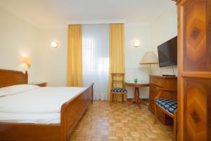 Casa Stefano في فيينا: غرفة نوم مع سرير وتلفزيون بشاشة مسطحة