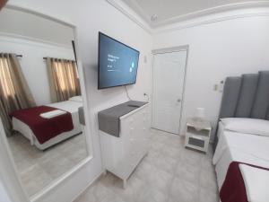 Casa Petter og Maria في سانتياغو دي لوس كاباليروس: غرفة نوم مع تلفزيون وسرير ومرآة