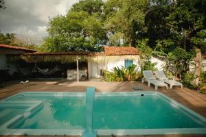 a swimming pool in front of a house at Pura Vida Hostel e Pousada - Boipeba in Ilha de Boipeba