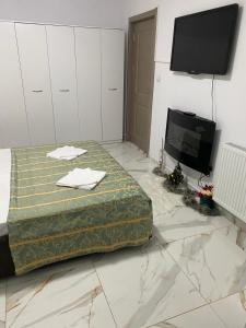 een slaapkamer met een bed en een flatscreen-tv bij Lemora Apartments in Focşani
