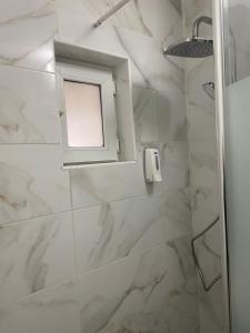 een badkamer met een douche en een raam bij Lemora Apartments in Focşani