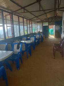 a room with blue tables and chairs and windows at Gaurishankar organic home stay in Dhulikhel